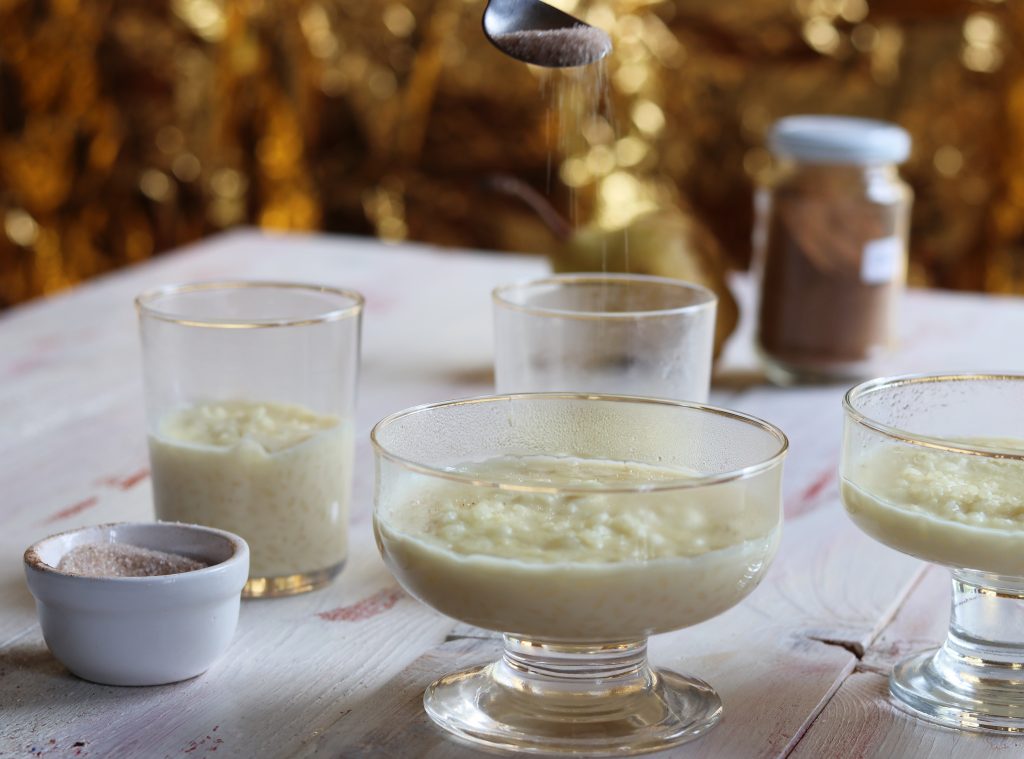Milchreis wird mit Zucker und Zimt bestreut
