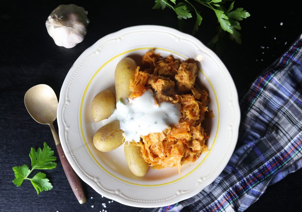 Veganes Szegediner Gulasch mit Kartoffeln, Dip und Petersilie auf einem Teller