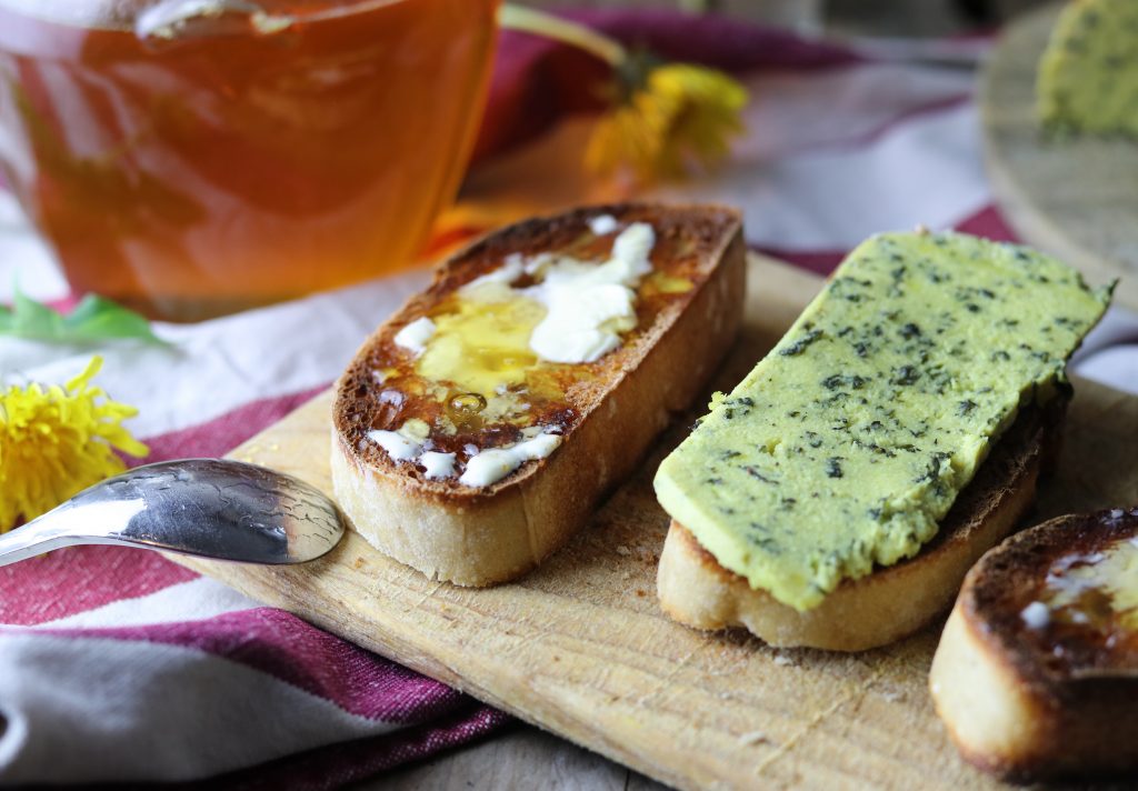 Löwenzahnhonig mit Margarine auf Brot. Daneben ein Brot mit meinem selbstgemachten Brennnesselkäse.