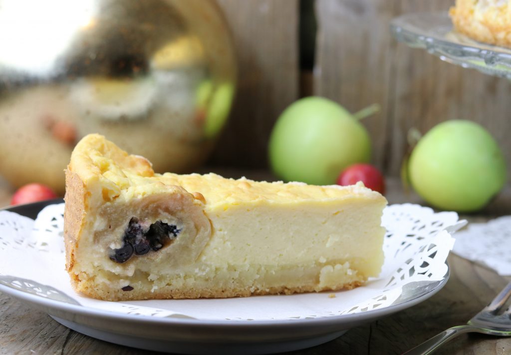 Ein saftiger, gefüllter Bratapfel ummantel von Käsekuchen auf Mürbeteig