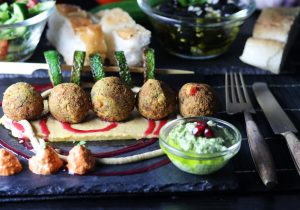 Mezze! Falafel mit Baba Ganoush Kern auf Hummus Bett, Muhammara, Granatapfelsauce, Grüner Tahini-Sauce, Knoblauch-Oliven, Salat und gegrillter Zucchini
