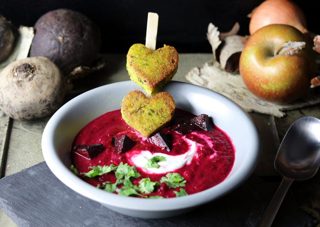 Rote Beete Apfel Suppe mit Polentaherzen-Spieß in einer grauen Schale