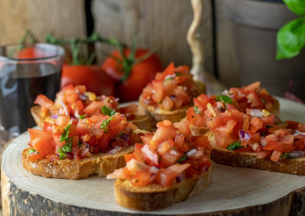 Mit gewürfelten Tomaten, Basilikum, Olivenöl auf mit Knoblauch geröstetem Brot