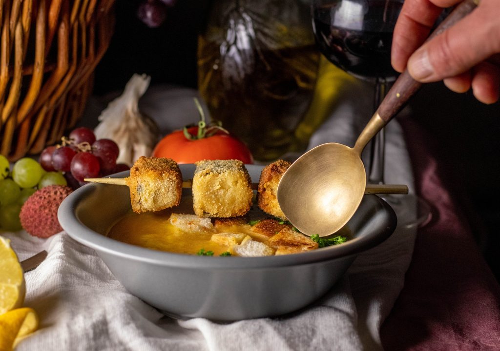 Sopa De Ajo - Mallorquinische Knoblauchsuppe - ein Löffel wird in die Suppenschale getunkt.