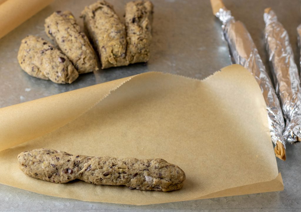 Das vegane Wurstbrät ein Backpapier einrollen, wenn man nicht mit dem Fleischwolf arbeitet.