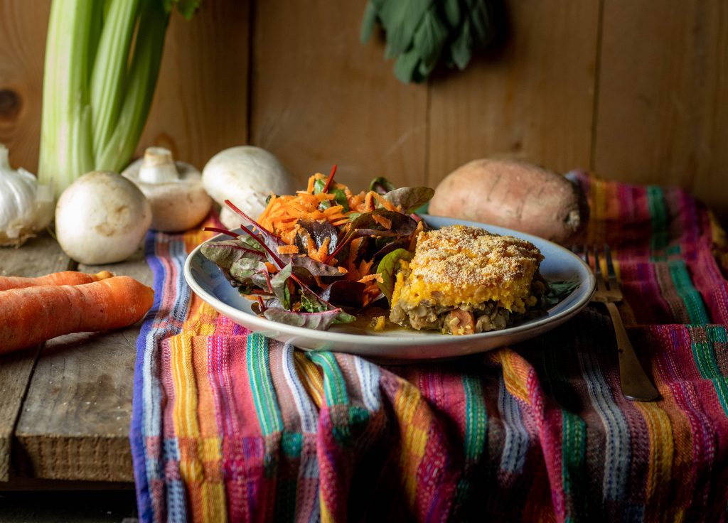 Süßkartfoffel-Linsen-Sheperd's Pie - vegan,auf einem Teller mit Salat