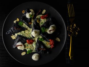 Schwarze Ricotta-Tomaten-Ravioli auf Petersiliensauce
