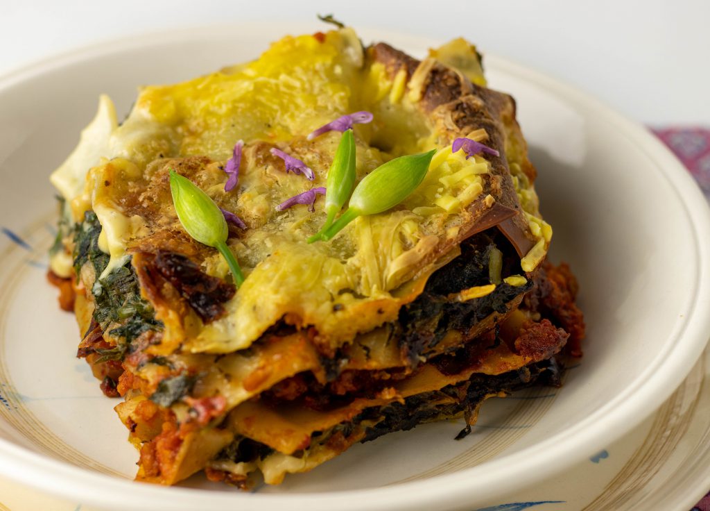 Wildkräuterlasagne mit Brennnessel, Bärlauch und Knoblauchsrauke auf einem Teller.
