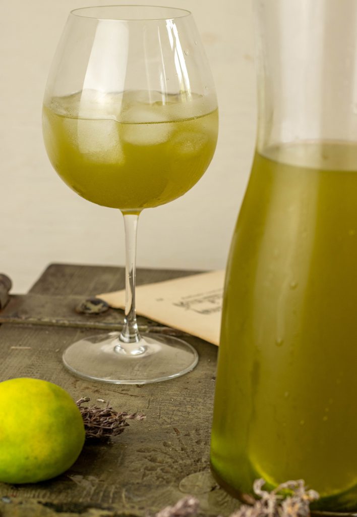 Matcha Limetten Eistee in einem Weingals und in einer Karaffe