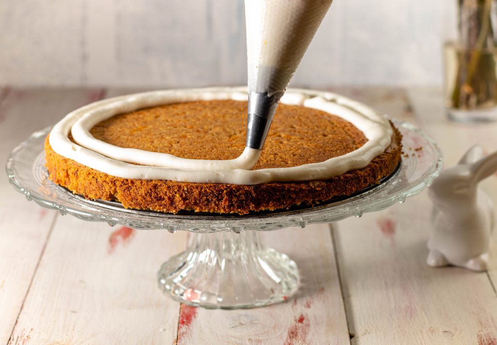 4. Der Kuchen ist ausgekühlt, geteilt und hier wird die untere Frischkäseschicht aufgetragen.