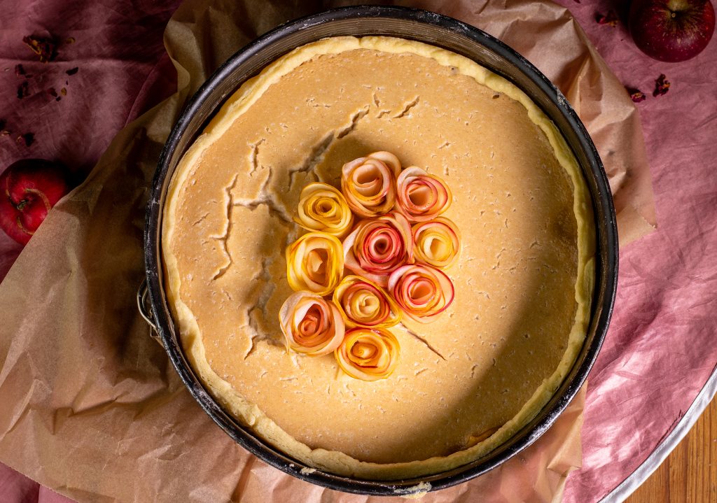 Belegen der Marzipan- und Puddingschicht mit den fertigen Apfelrosen