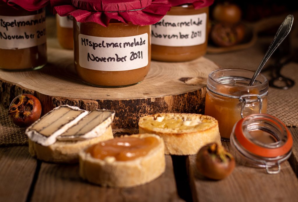 Mispelmarmelade auf Brot und in Schraubgläsern.