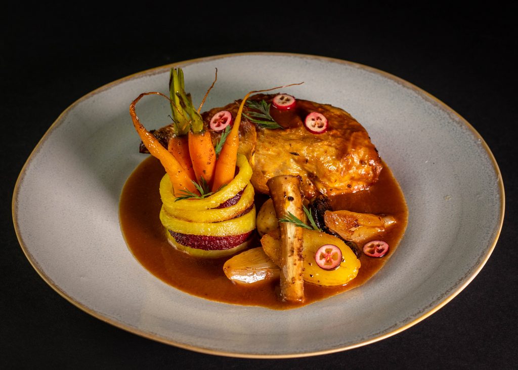 Vegane Gänsekeule. Als Beilage gibt es das Backobst und Wurzelgemüse aus dem Bräter. Außerdem einen Ring aus gerösteten Kartoffeln und Beete mit knackigen Zatarmöhrchen darin.