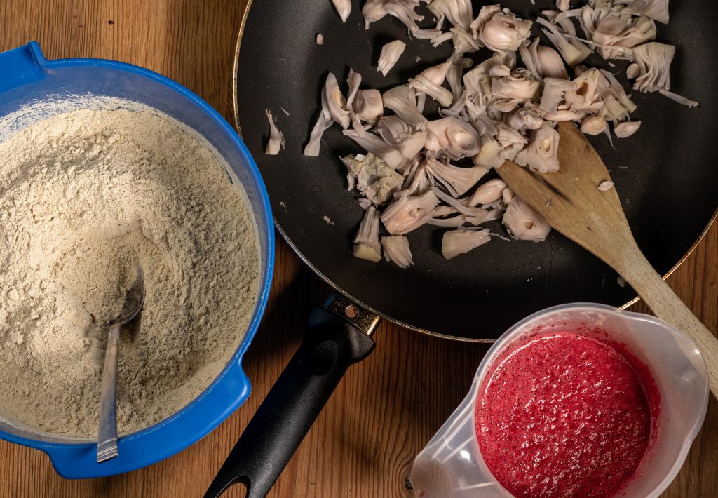 1. Die Zutaten für den veganen Sauerbraten. Der Seitan ist mit den trockenen Zutaten vermengt, die Jackfruit wir in der Pfanne mit Brühe gegart und die nassen Zutaten werden miteinander püriert.