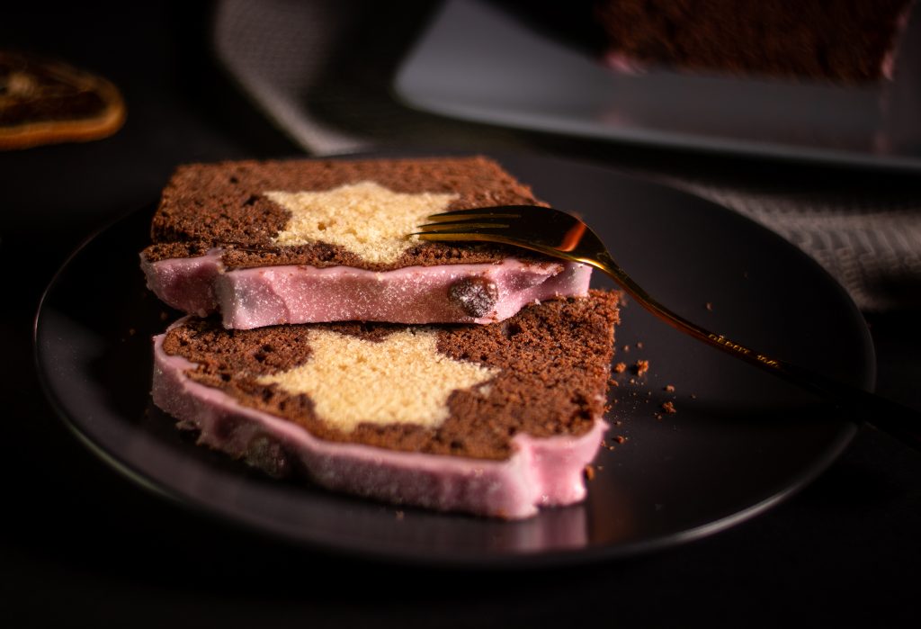 Schokopunschkuchen mit eingebackenem Vanillestern. Zwei Stücke auf einem Teller.