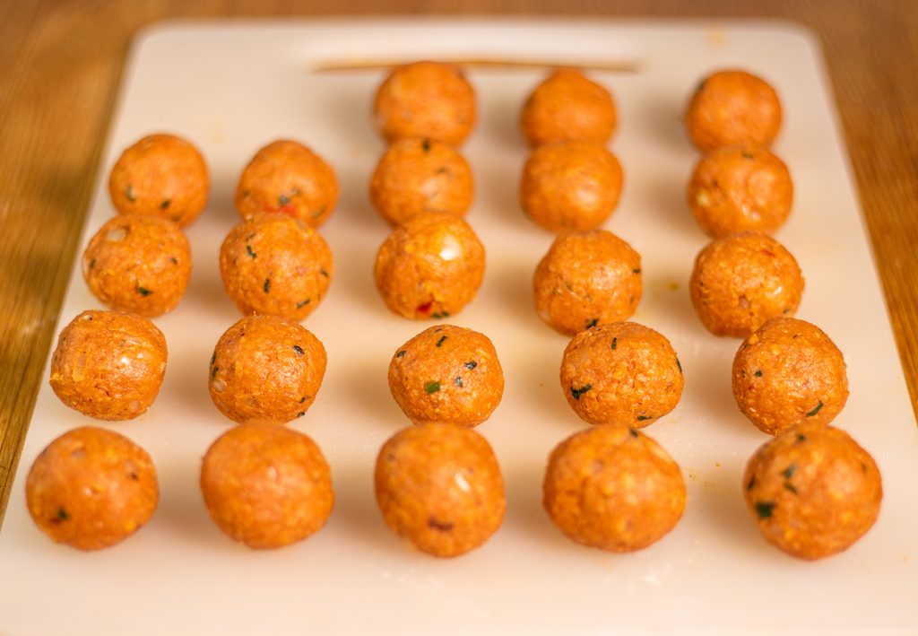 Vegane Hackbällchen nach dem Formen, vor dem Braten auf Küchenbrett