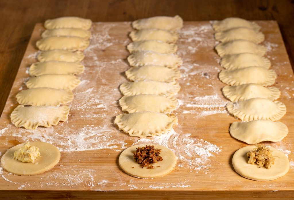 Rohe, vegane Piroggen mit 3 Füllungen: Kartoffel-Quark, Hack-Pilz und Sauerkraut-Pilz. EInige Piroggen sind noch offen.