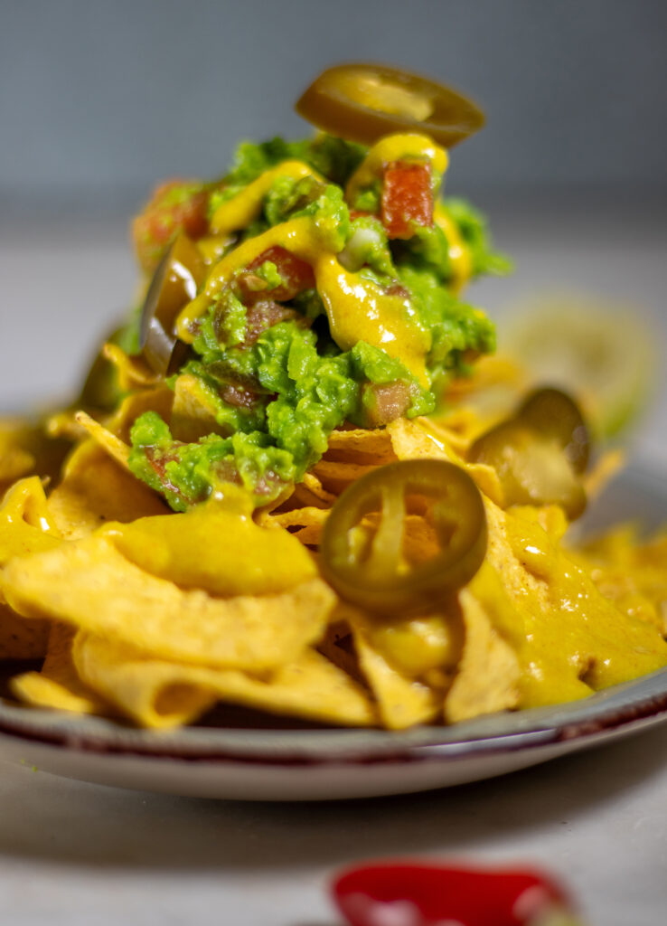 Erbsguacamole,vegane Käsesauce und Jalapenos auf Tortilla Chips