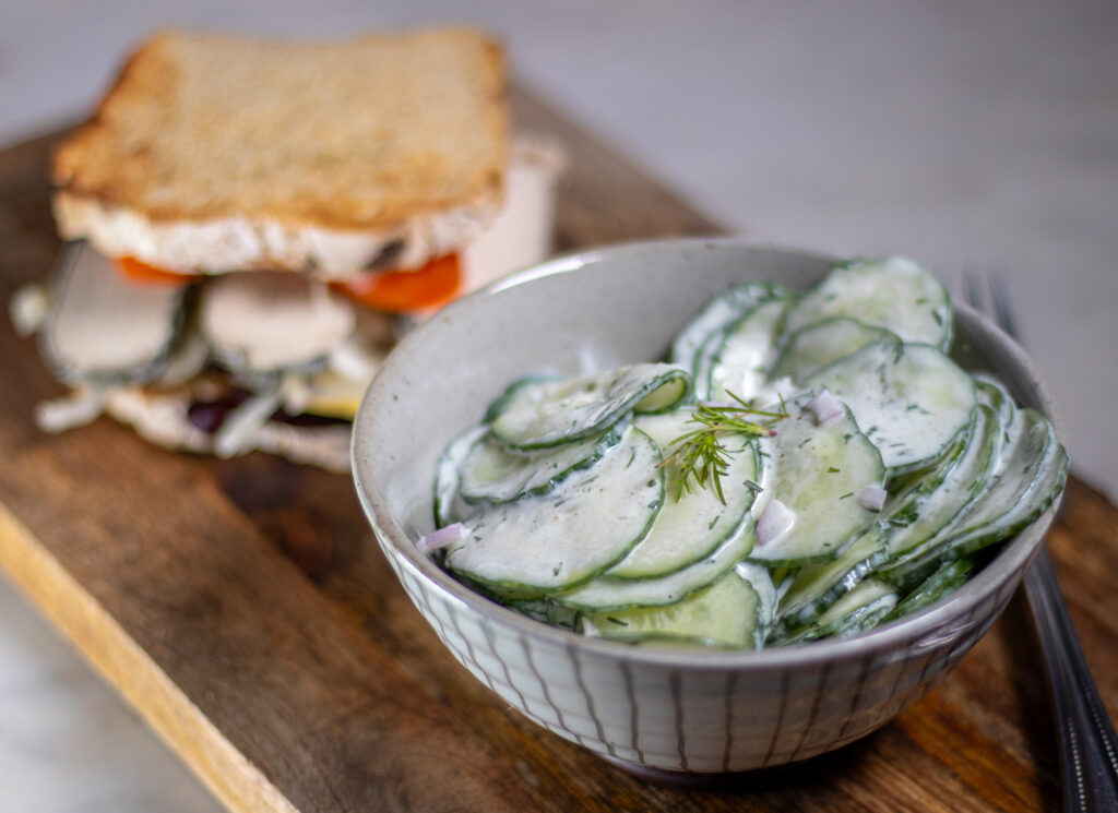 Gurkensalat mit Sahnedressing passt als Beilage zu vielen Speisen