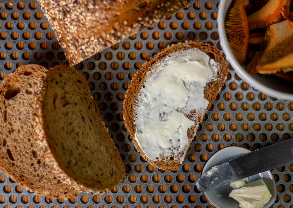 Die Brotscheiben dick mit veganer Butter bestreichen