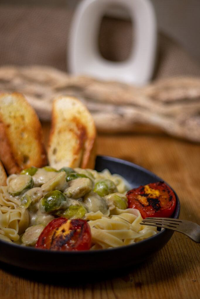 Rosenkohl Tagliatelle mit geröstetem Brot und gebratenen Tomaten.