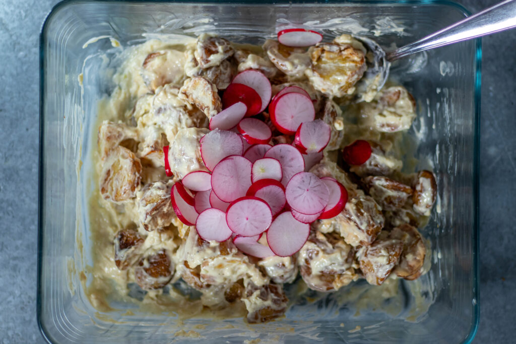 4. Die Röstkartoffeln für den Salat mit dem Myaodressing verrühren, dann noch die Radieschen unterheben.