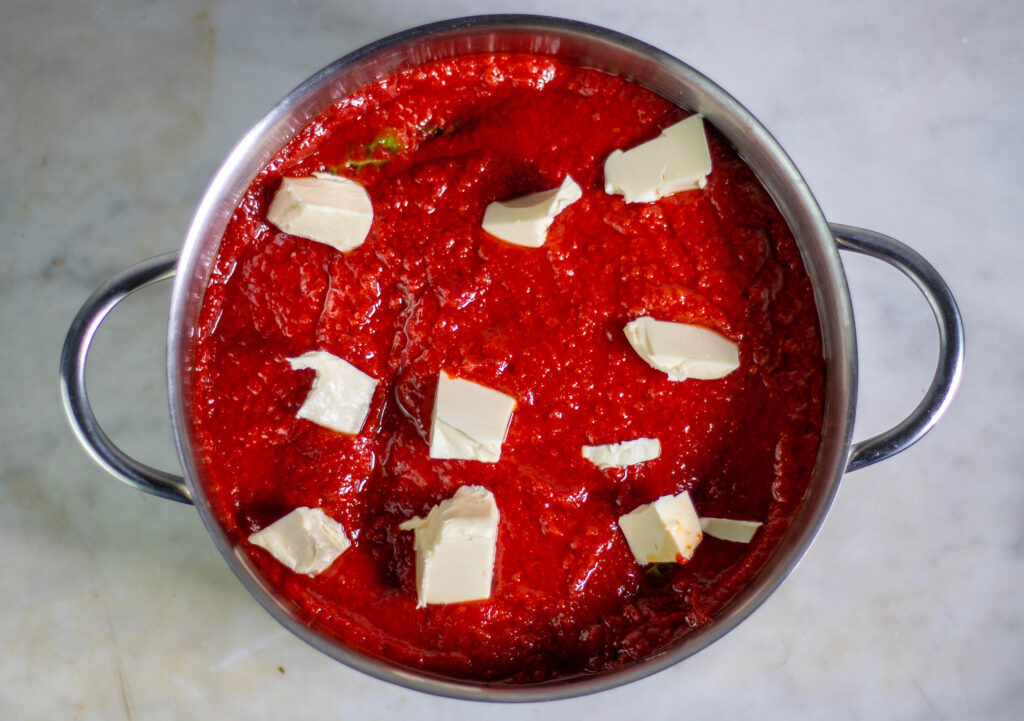 4. Mit der Tomatensauce und den veganen Butterstückchen auffüllen.