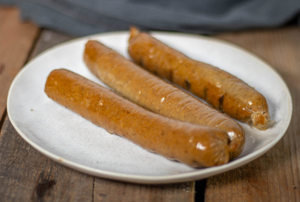 Rauchig, saftig, deftig, fett, aromatisch. In meinem Rezept bereite ich die vegane Wurst mit einer essbaren, pflanzlichen Wurstpelle zu. Und ich räuchere die Bremer Pinkel anschließend.