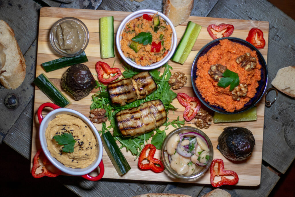 Muhammara auf einer reichhaltigen Mezzeplatte mit Baba Ganoush, Kisir, Hummus, Piyaz, Dolma und gefüllten Auberginenröllchen