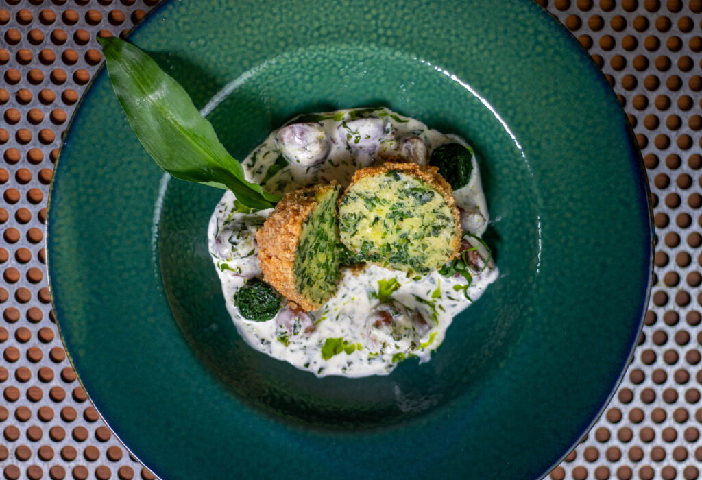 Auf den Fotos siehst Du meine grünen Bärlauchknödel im Knuspermantel auf einer aromatischen, cremigen Champignon-Bärlauch-Sahne-Sauce.