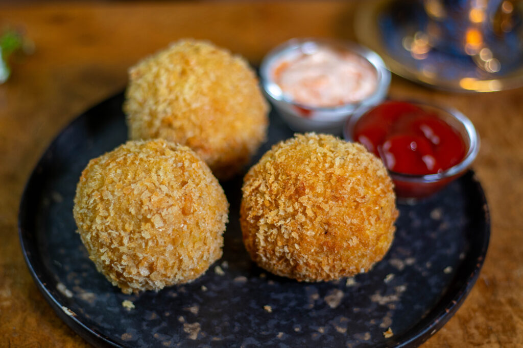 Am besten genießt man diese panierten Maccaroni and Cheese Bällchen mit einem aromatischen Dip.