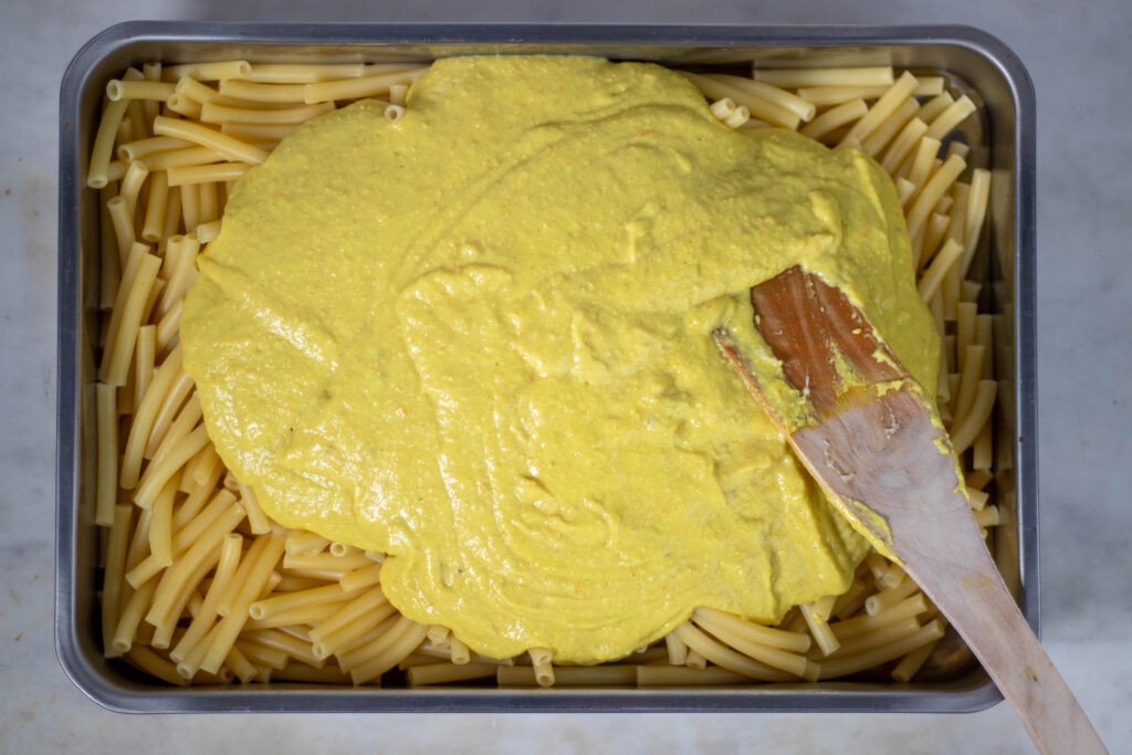 3. Käsesauce und Bechamelsauce sind vermischt und werden jetzt mit den gegarten Nudeln vermengt.