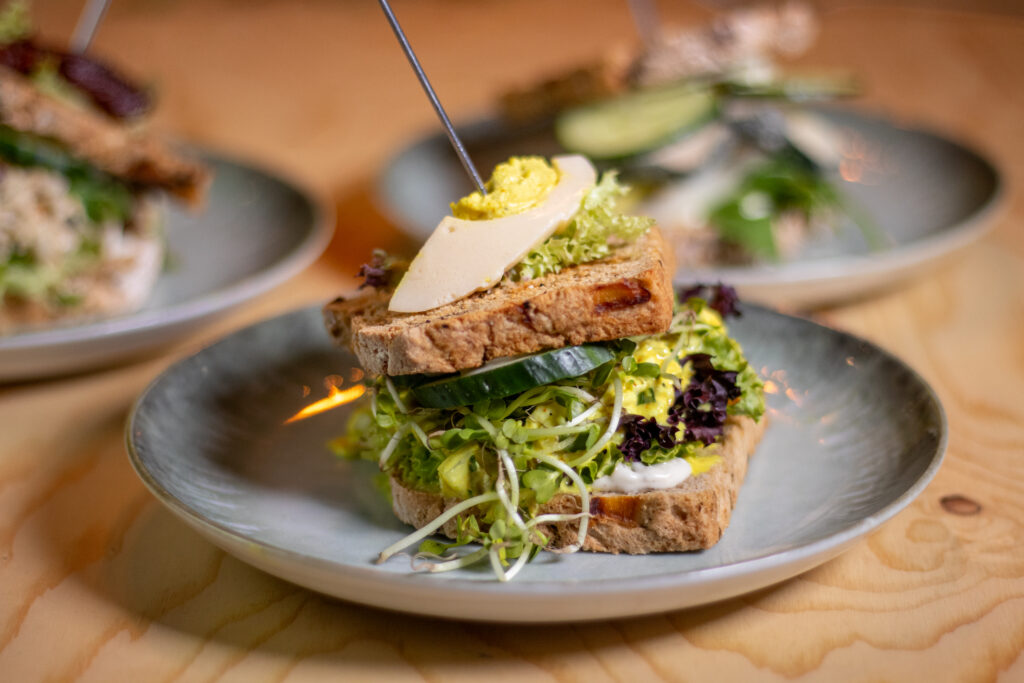 Unser Feiersalat-Sandwich in meinem ehemaligen Restaurant. Mit veganem halben Ei, veganem Eiersalat, Sprossen und Gurke.