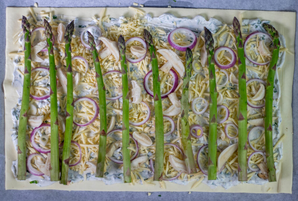 5. Zum Schluss wird die Tarte mit Maipilzen und grünem Spargel belegt. Jetzt muss sie nur noch für 20 Minuten in den Ofen.