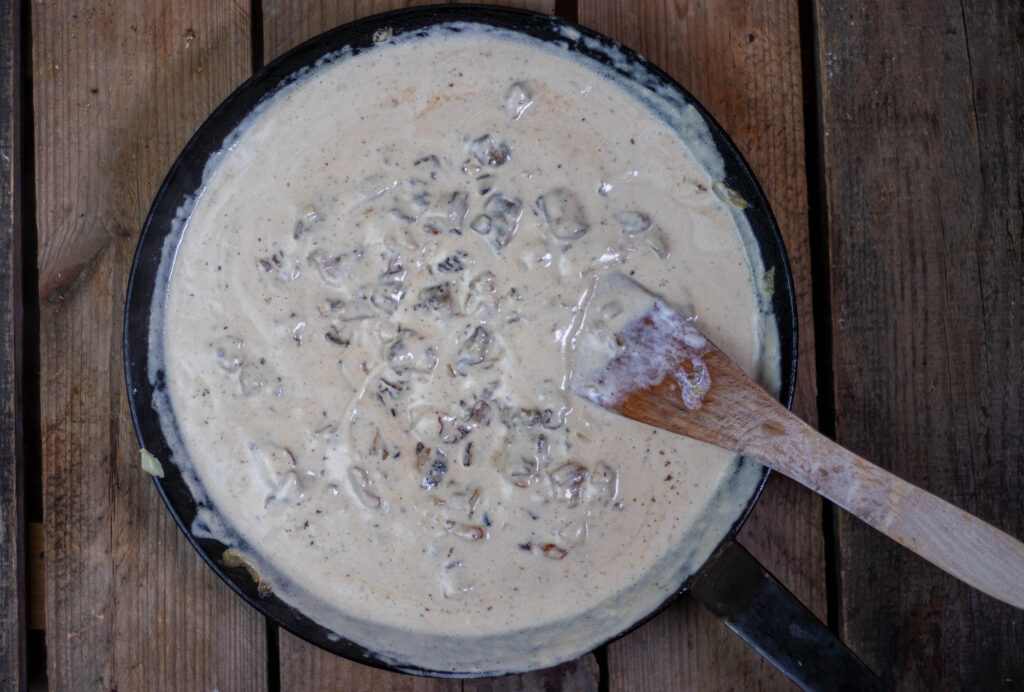 4. Sahne und Creme Fraiche einrühren, etwas köcheln lassen und mit Salz und Pfeffer abschmecken.