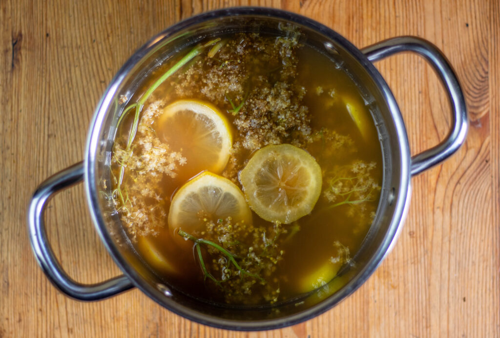 3. Den Apfel-Zitronen-Holunderblüten-Sud nach 2 Stunden kurz aufkochen und über Nacht erneut ziehen lassen.