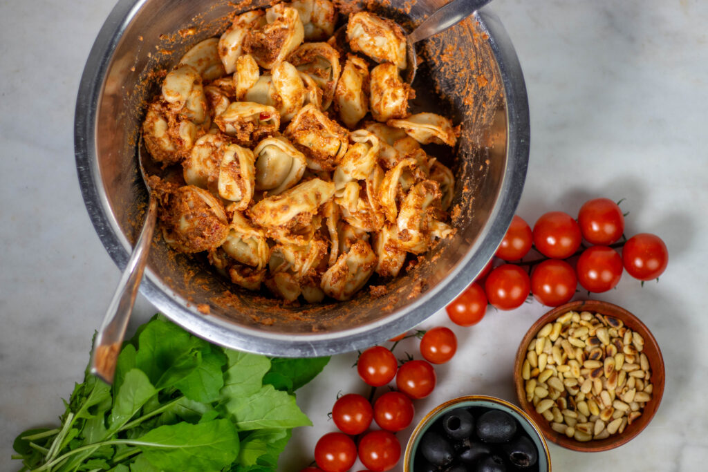 3. Das rote Pesto unter die Tortellini mischen.