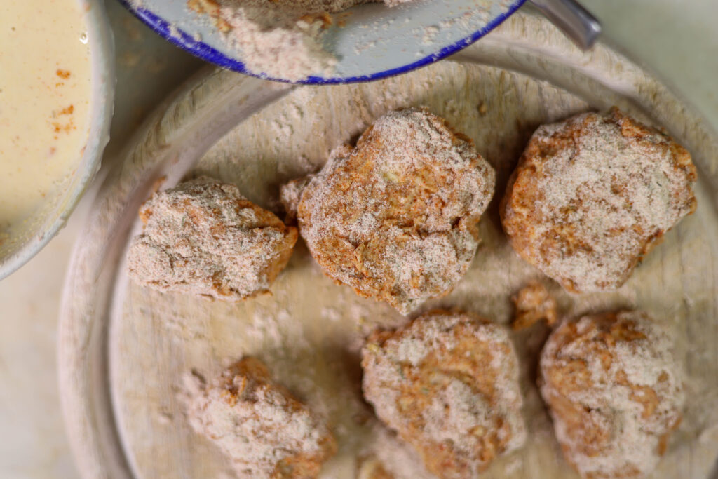 6. Die Wiesenstäubling-Nuggets dick panieren. Dafür mehrfach in der Panade wenden.