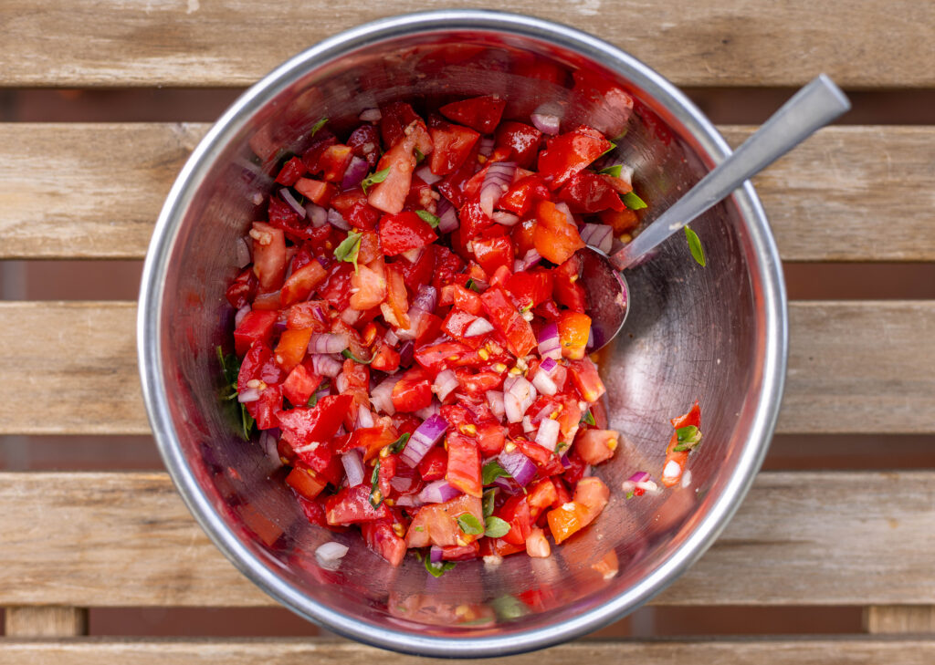3. Alle Zutaten für den Tomatenbelag werden vermengt und mit Salz und Pfeffer abgeschmeckt.
