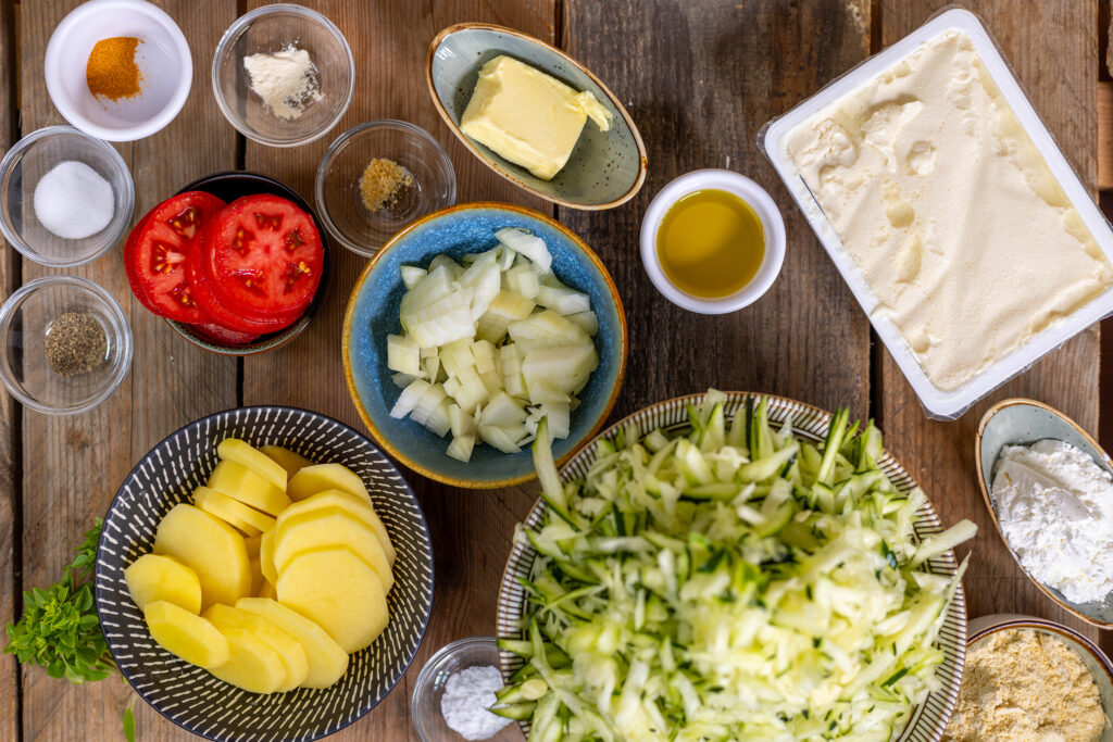 2. Die Zucchini ist gerieben, die Zwiebeln, Kartoffeln und Tomate sind geschnitten.
