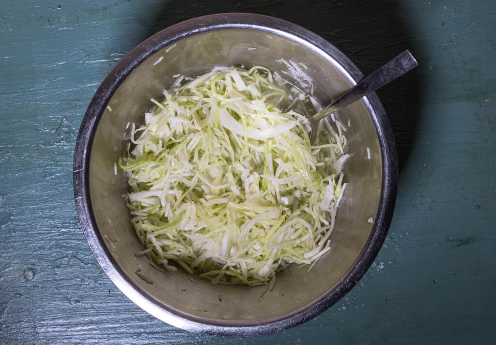 5. Das Dressing wird mit Kohl und Zwiebeln vermengt, dann sollte der Krautsalat einen Tag im Kühlschrank ziehen.