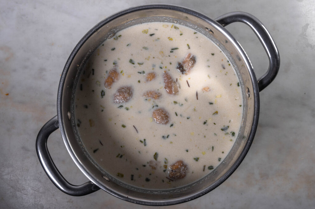 6. Nach und nach die Brühe, vegane Creme Fraiche und den Zitronensaft einrühren und etwa 20 Minuten köcheln lassen.