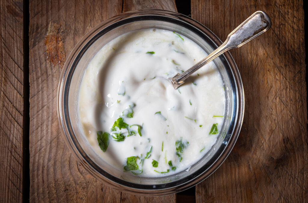 Eine Schale mit veganem Joghurt-Dip und einem Löffel darin.