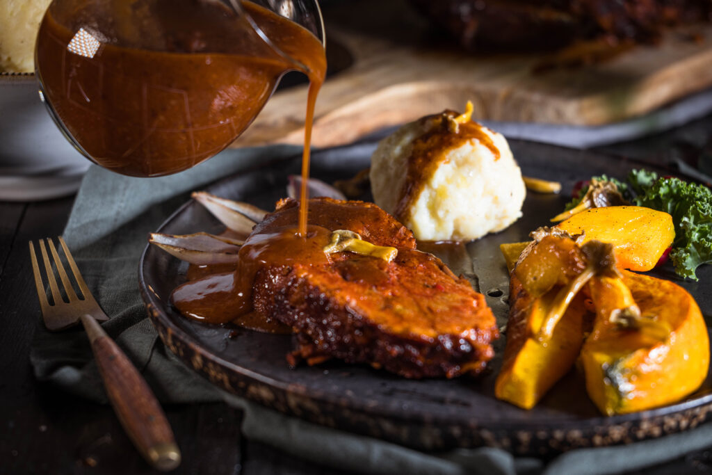 Veganer Sauerbraten mit der Sauce vom Sauerbraten, Kartoffelknödeln, Kürbisspalten und eingelegten Pilzen