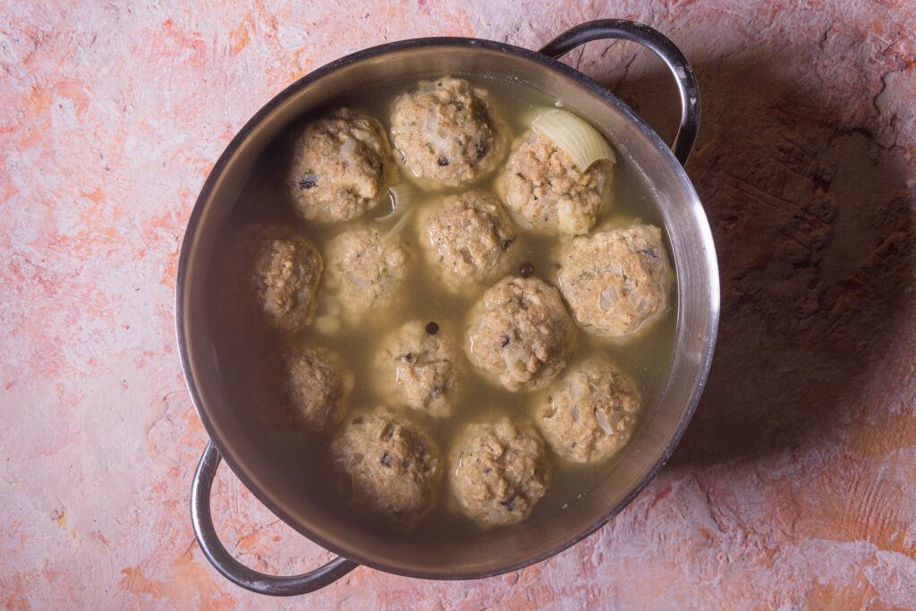Königsberger Klopse in einem Topf mit Brühe.