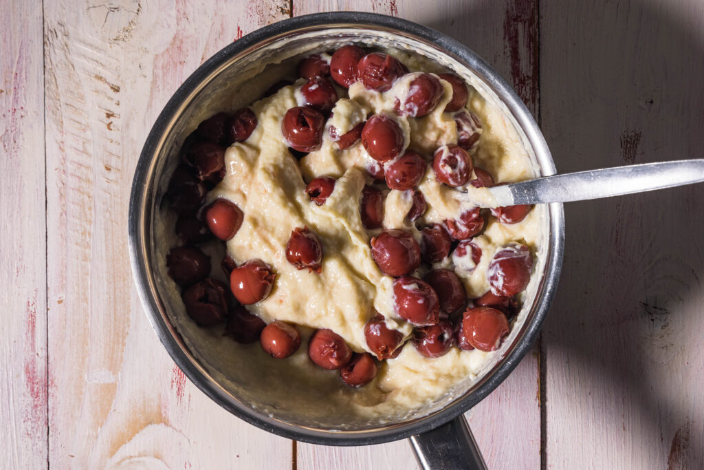 Kirschen werden unter eine Strudelfüllung gehoben.