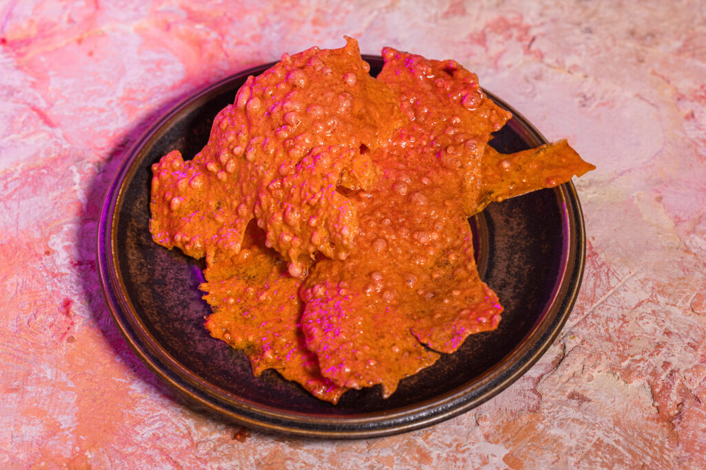 Gepuffte Rote Cracker auf einem braunen Teller
