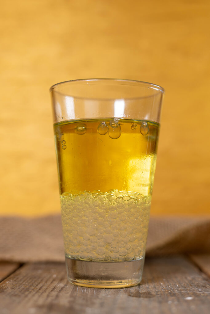 Ingwer-Perlen setzen sich unten in einem Glas mit kaltem Öl ab.