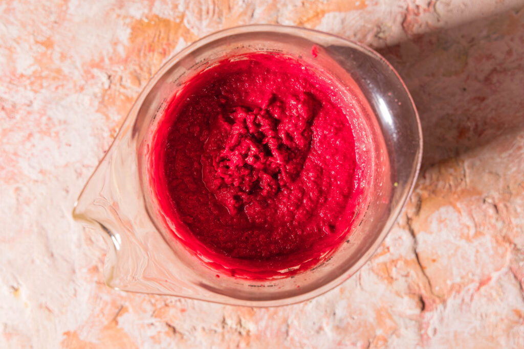 Alle Zutaten für den Rote Beete Hummus miteinander püriert in einem hohen Gefäß.