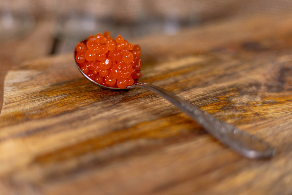 Sriracha-Kaviar – kleine Perlen, auf einem Löffel.